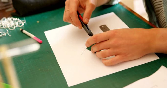 Jewelry designer cutting layout of design paper 4k
