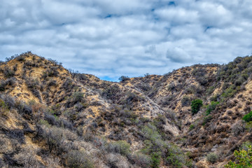 Fototapeta premium Dry hillsides on inland foothills with morning clouds in the sky