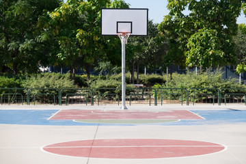 Afroamerican young man playing street basketball in the park