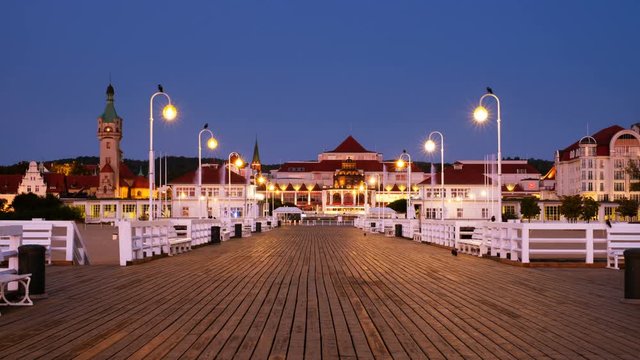 Sopot, Poland. A sunrise time-lapse of a long wooden pier in Sopot, Poland, with a view of the lighthouse and other old town signature buildings.