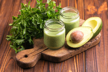 Fresh spinach and avocado smoothie in glass jars