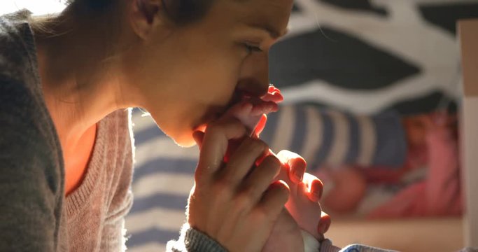 Mother kissing her baby feet at home 4k