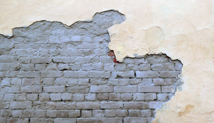 Old brick wall with fallen off plaster