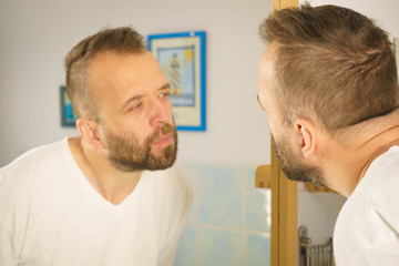 Fototapeta premium Man looking at himself in mirror