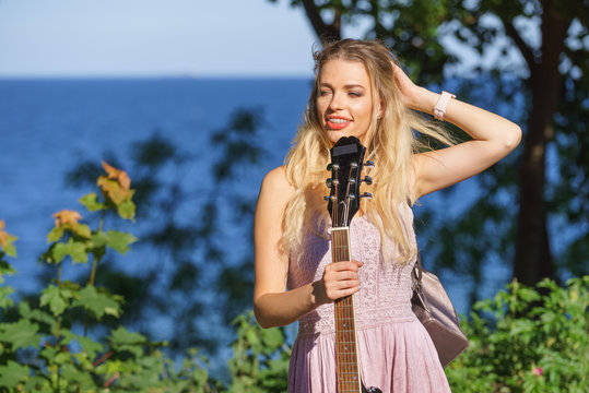 Woman playing acoustic guitar in park