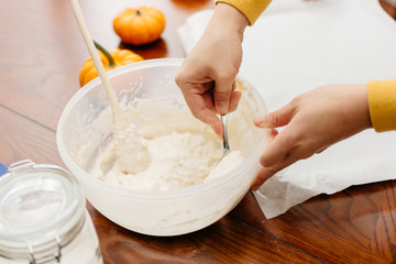 Woman hands mixing dough on wooden table