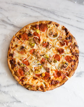 Whole pizza over marble surface.