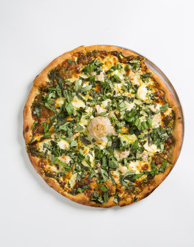 Whole Pizza on a dish over white surface.