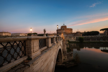 Castle Sant Angelo, bridge Sant Angelo and river Tiber in the rays of sunrise in Roma, Italy.