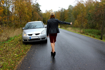 the autumn day the car broke down and the girl in a dress with a hat catches another car to help