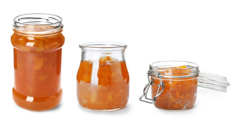 Set with jars of delicious peach jam on white background