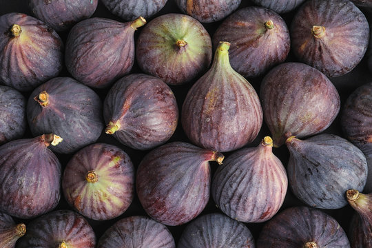 Many whole fresh purple figs as background, top view