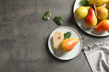 Flat lay composition with ripe pears on grey background. Space for text