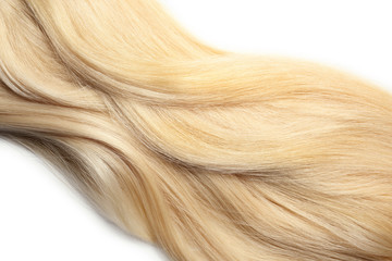Strand of healthy blond hair on white background