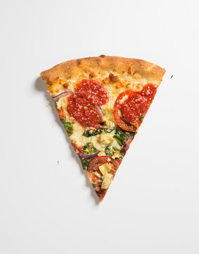Pizza slice on a white surface.