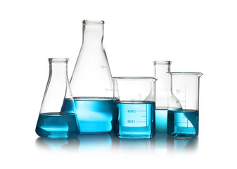 Laboratory glassware with liquid on table against white background. Chemical analysis