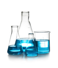 Laboratory glassware with liquid on table against white background. Chemical analysis