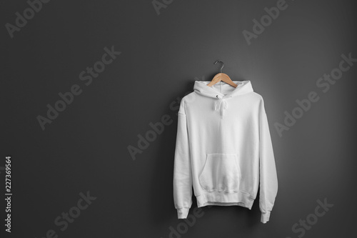 Download "New hoodie sweater with hanger on grey wall. Mockup for ...