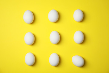 Raw chicken eggs on color background, top view
