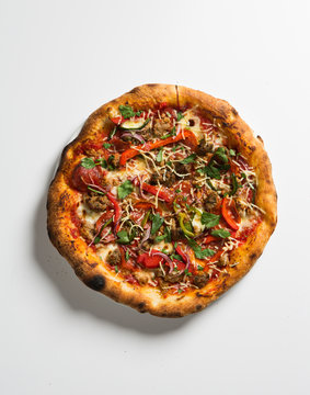Whole pizza over white surface.