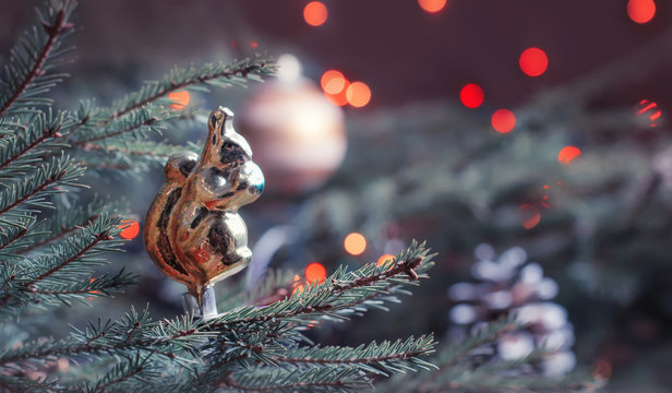 Vintage Christmas toy on the Christmas fir tree, toned image, selective focus