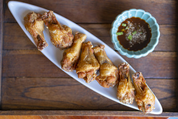 chicken fried and sauce on plate, wood board background.
