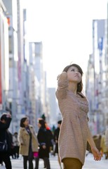Fototapeta na wymiar Japanese Girl poses on the street in Ginza, Japan. Ginza is a shopping city located in Tokyo.