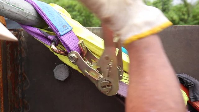 Worker securing cargo transportation with strap