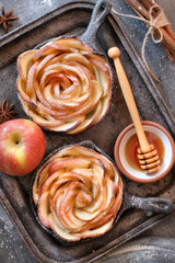 Homemade puff pastry with rose shaped apple slices baked in iron skillet