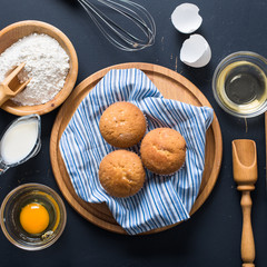 Baking ingredients. Bowl, eggs, flour, eggbeater, rolling pin and eggshells on black chalkboard from above.