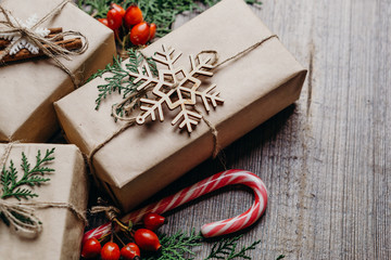 Christmas and New Year poster or greeting card template, composition with gift boxes, evergreen branches and candies on rustic background. Winter holidays celebration concept