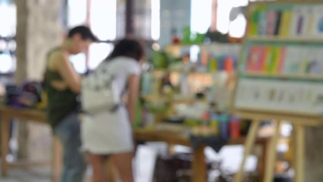 Blurred Background. Woman standing near the counterand buys different things in a shop