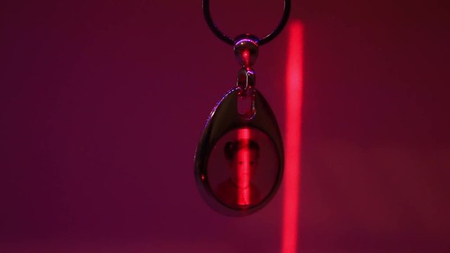 Close Up of the Hanging Child's Photo in Metal Souvenir Keychain and the Moving Laser Light.