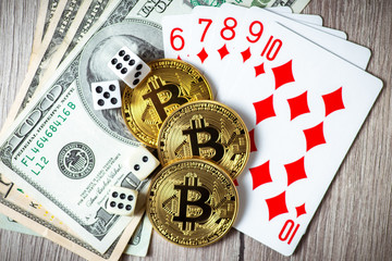 Bitcoins, cards, dices on wooden background. Cryptocurrencie gambling concept