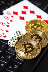 Bitcoins, cards and dices on keyboard. Cryptocurrencie gambling concept
