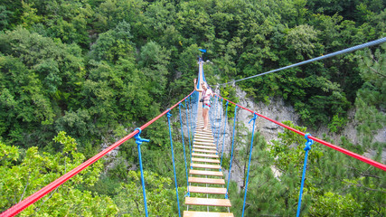 girl goes on a suspension bridge over the canyon of Crimea