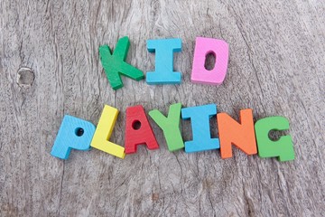 Colorful wooden alphabet blocks with wording kid playing on wooden floor 