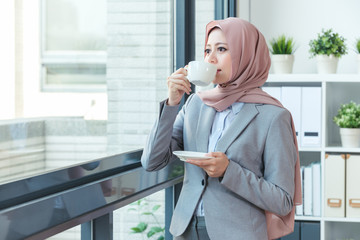 Muslim office lady drinking coffee at office.