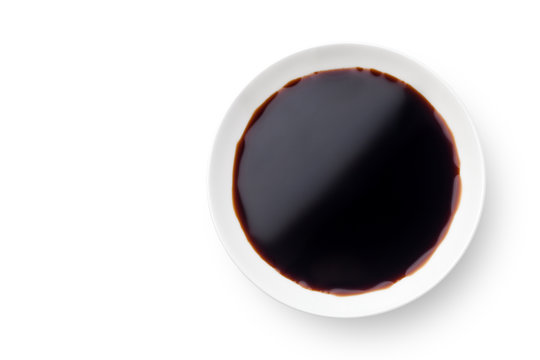Dish of soy sauce isolated on white background. Top view.