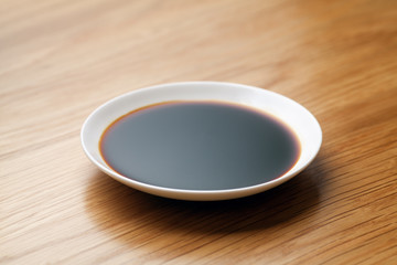 Dish of soy sauce on the wooden table