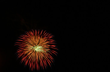 Fototapeta premium Single red, orange, and yellow starburst firework in black sky on Fourth of July
