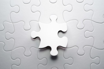The correct solution. Solving and completing the task.Last piece of jigsaw puzzle. Assembling white jigsaw puzzle pieces.