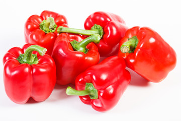 Fresh red peppers lying on white background, healthy nutrition concept