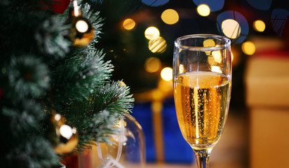 Glass Of Champagne Beside Christmas Tree. Close Up Shot