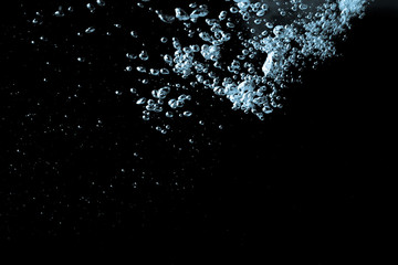 Pouring water has an abstract bubble on a black background