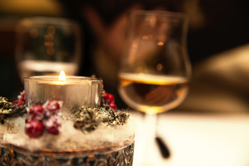 Naklejka na ściany i meble Glass of alcohol and a candle on the table