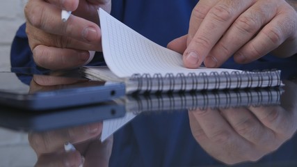Businessman in Office Using a Pocketbook for Writing Information