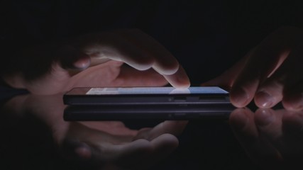 Man Hands Using Mobile Wireless Application in Darkness