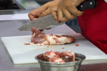 Chef preparing food, meal, chicken in the kitchen, chef cooking cutting the meat on a board