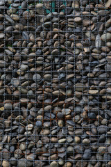 Old rusty metal grate filled with stones.